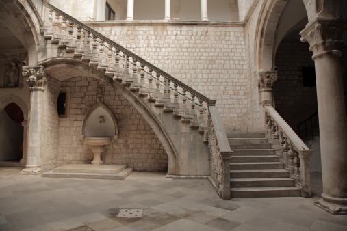 Stone stairs with Roman styling in a courtyard.