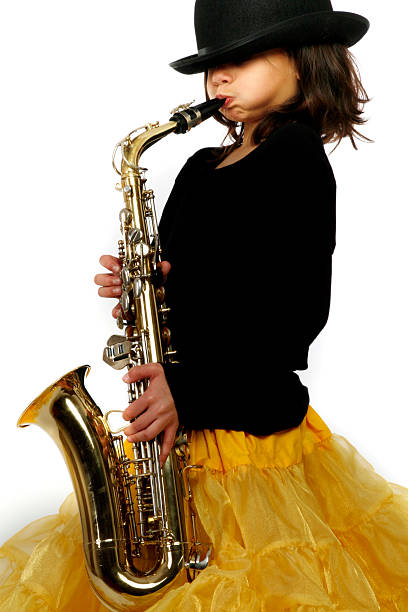 Little girl wearing yellow skirt playing the saxophone  stock photo