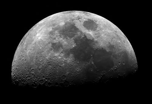 First-quarter moon taken through a telescope showing lots of detail.