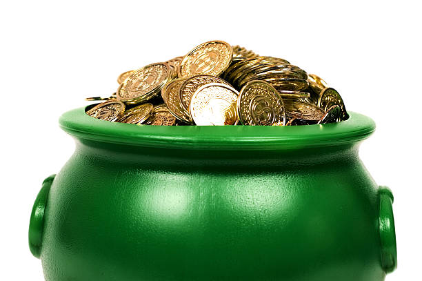 A green pot with lots of gold coins in it stock photo
