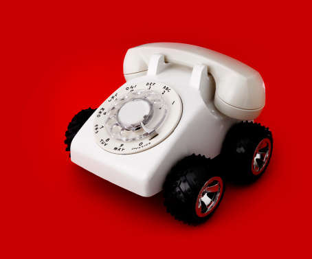 a white vintage phone with wheels