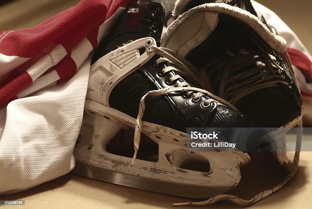After The Game Close-up of a pair of well worn hockey skates and hockey jersey Old Stock Photo