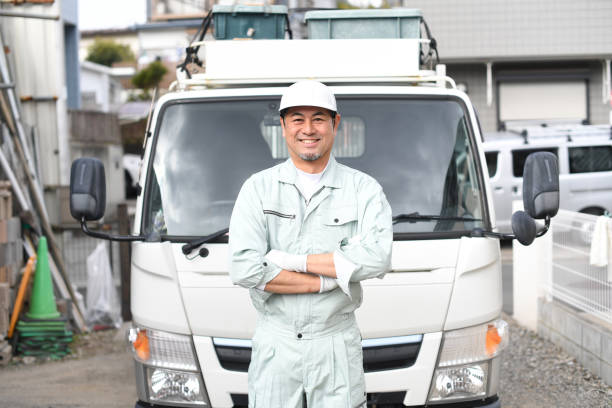 A middle-aged man wearing work clothes with his arms crossed in front of a truck A middle-aged man wearing work clothes with his arms crossed in front of a truck steeplejack stock pictures, royalty-free photos & images