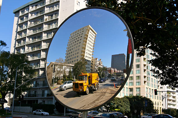 Street Sweeper in the Convex Mirror Los Angeles city street sweeper seen in a large mirror with traffic and apartments around on Wilshire Blvd. convex stock pictures, royalty-free photos & images