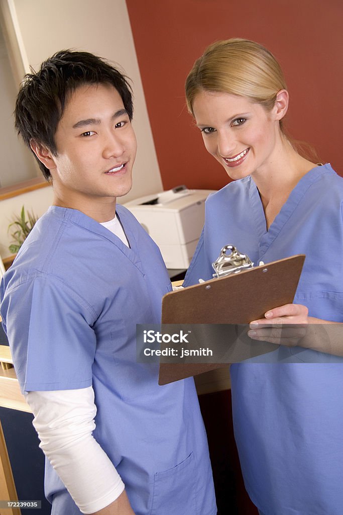 Alla stazione di infermieri sorridente infermiere - Foto stock royalty-free di Accudire