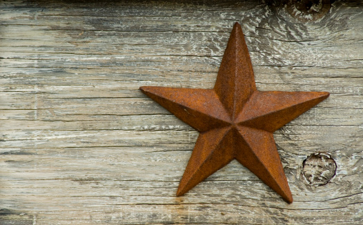 iron texas star on wood background - space for text