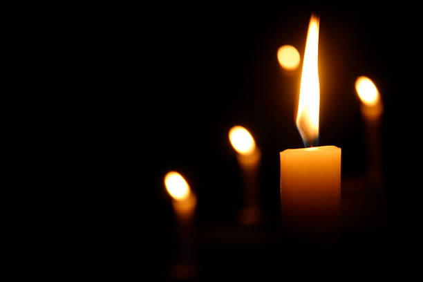 candele burning in chiesa scuro - alight candle foto e immagini stock