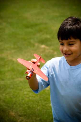 Child playing with a paper airplane