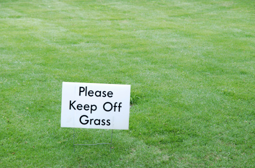green grass with sign warning to keep off