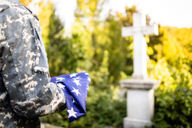 złożona amerykańska flaga na cmentarzu w dniu pamięci. - marines funeral veteran us memorial day zdjęcia i obrazy z banku zdjęć