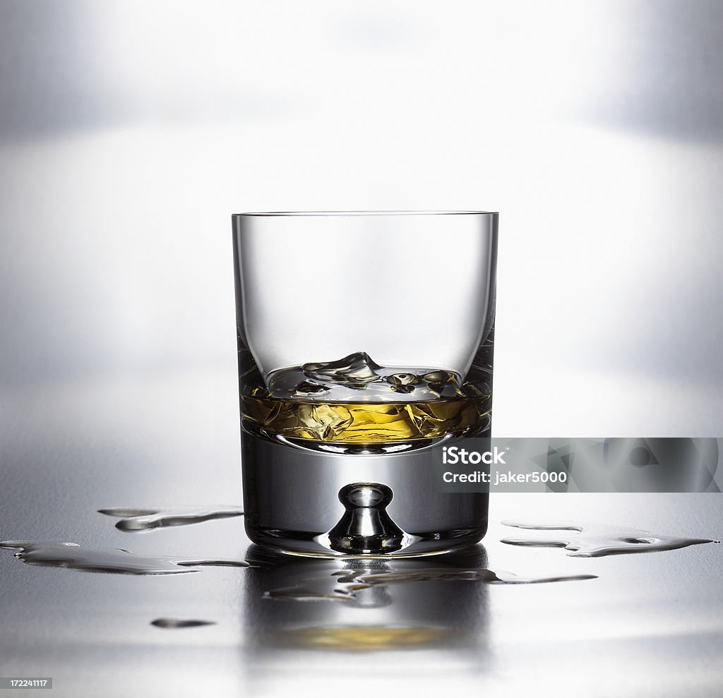 scotch on the rocks "Glass of scotch on ice, sitting on bright brushed metal surface." Alcohol - Drink Stock Photo