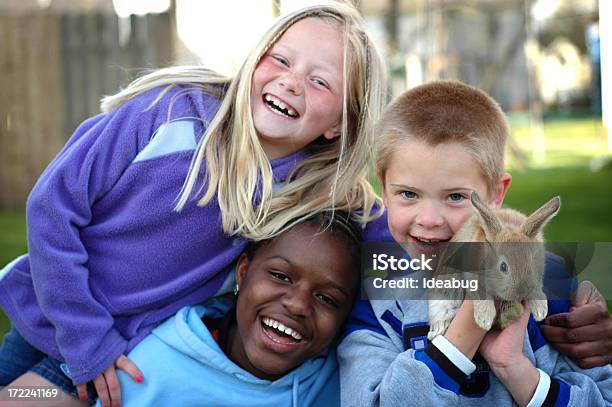 Two Girls And A Boy Laughing Together Outside With Bunny Stock Photo - Download Image Now