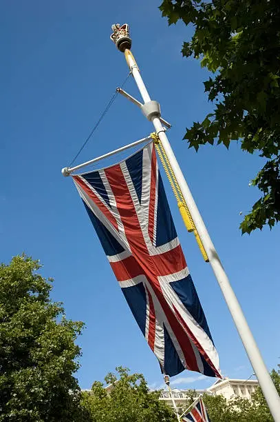 A union jack flag on a flagpole topped with a crown.