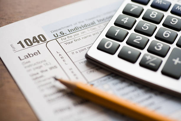 Close-up of a tax form, calculator, and pencil.  Shallow DOF.