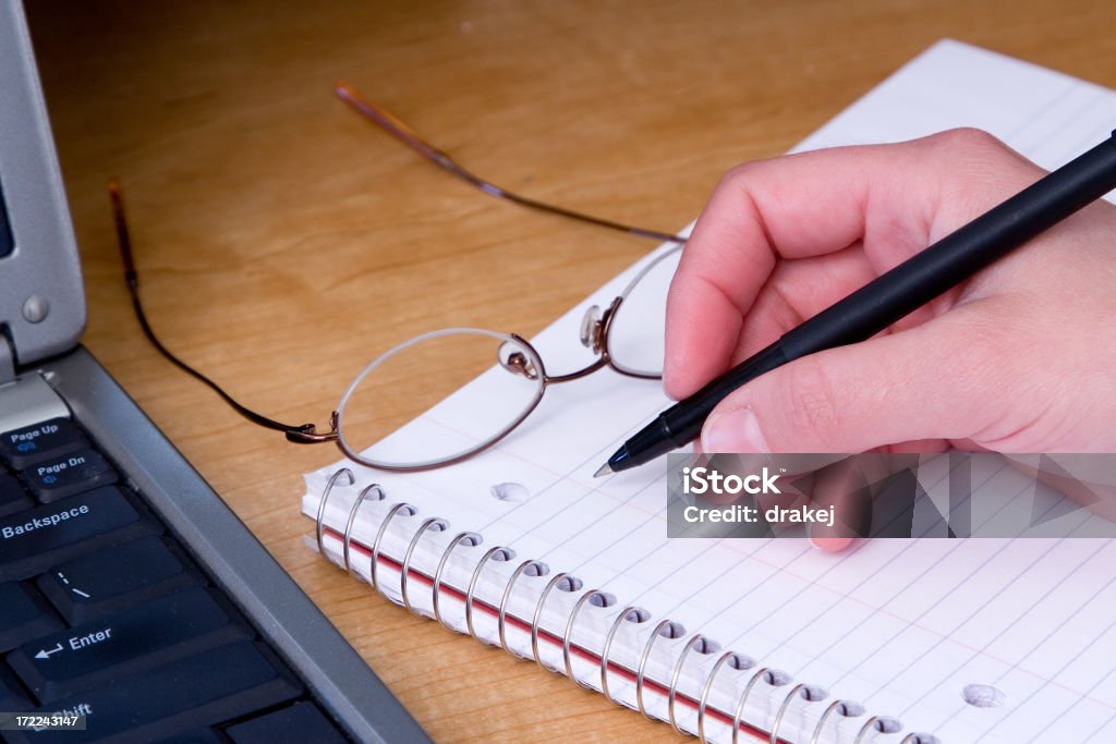 Best of Both Worlds Woman takes notes manually next to a computer keyboard. Adult Stock Photo