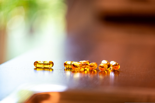 Multiple organge capsules filled with liquid coenzyme Q10 coq10 on a kitchen counter