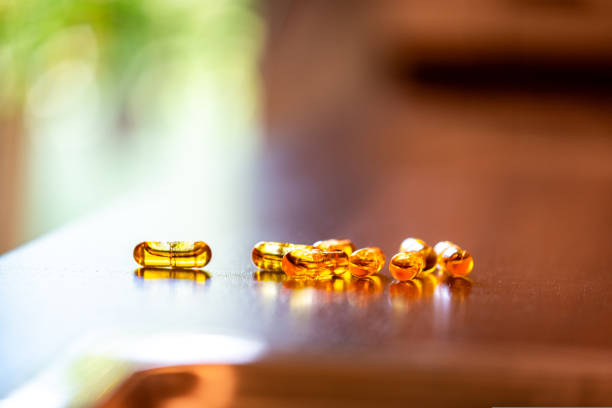 несколько кап�сул с коэнзимом q10 коэнзим q10 на кухонном столе - anti aging pill capsule vitamin pill стоковые фото и изображения