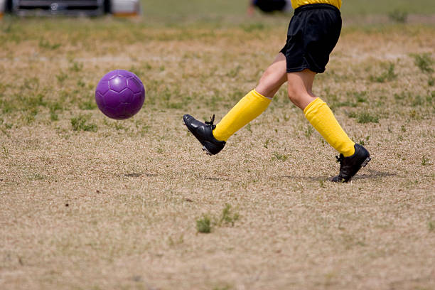 bunte fußball kick - soccer action child purple stock-fotos und bilder