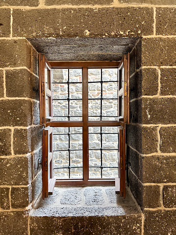 Window with a metal lattice in a stone wall
