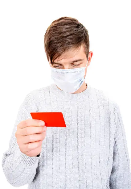 Young Man in Flu Mask hold a Bank Card Isolated on the White Background