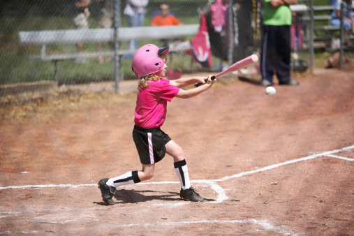 little girl hits the baseball