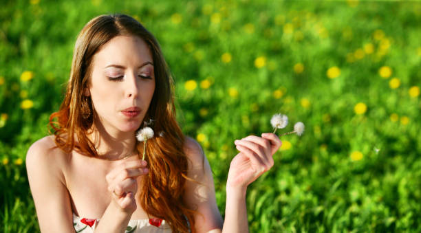 istock Young woman blowing dandelion 172244087