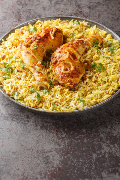 istock Bangladeshi spicy roast chicken served with aromatic pilaf close-up in a plate. Vertical 1722443708