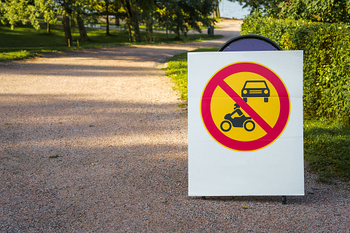 No motor vehicles sign next to a gravel road in a park