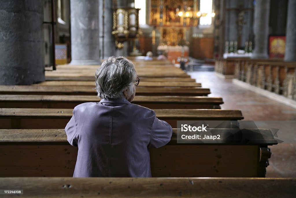 Femme en prière d'une église, presque vide, vue de dos - Photo de Église libre de droits