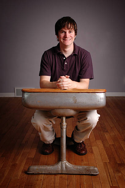 Happy Young Man Student Sitting in Old School Desk