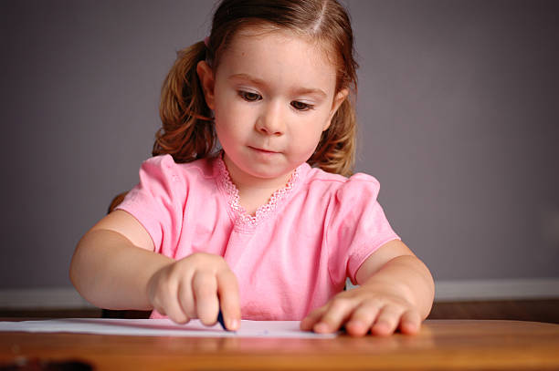 istock Little Girl in School Desk Learning to Write 172247222