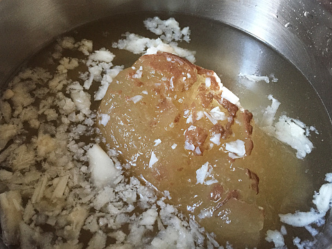 Frozen bone broth in cooking pan. Boiled bone broth in saucepan