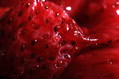 Pieces of strawberry jam on a spoon. Sweet juicy background. Macro closeup.