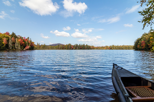 Pond in Autumn surrounded by Colourful Trees Reflecting in the Calm Waters along with the Blue Sky with Clouds. Southford State Park, CT.