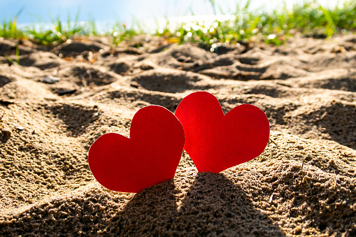 Two Red Hearts in the Sand at the Summer Beach