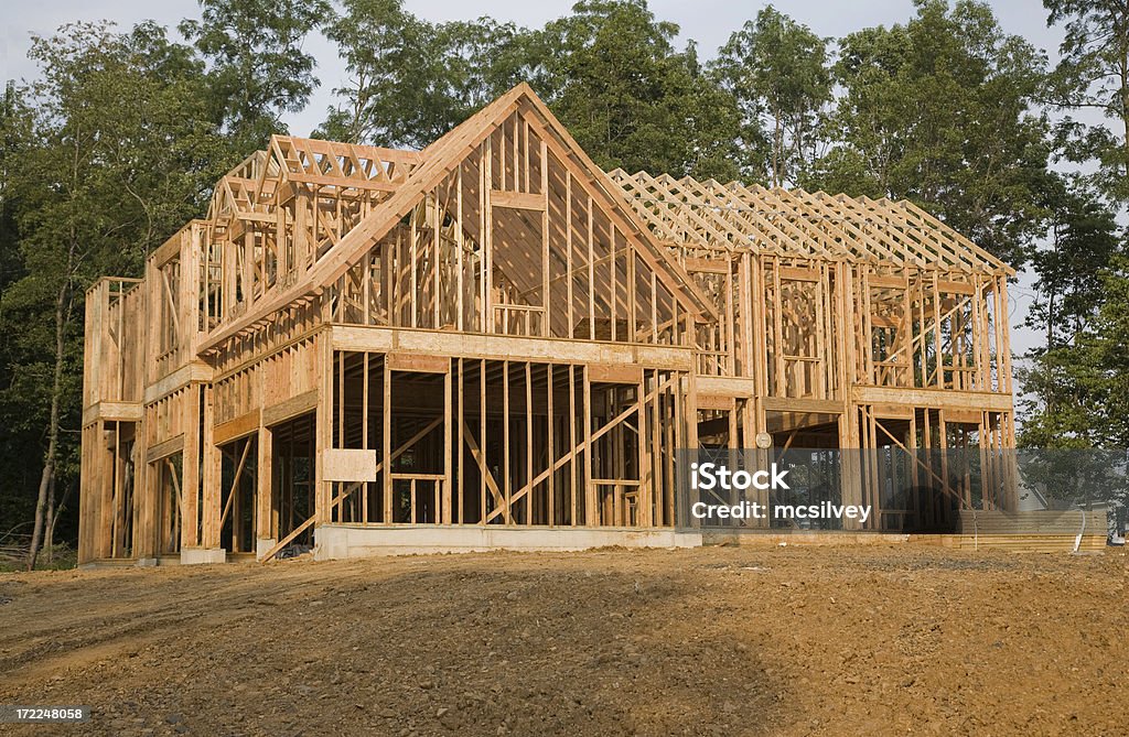 Framing A large house on a wooded lot sits in the late stages of framingLightbox of House Framing: Building Exterior Stock Photo