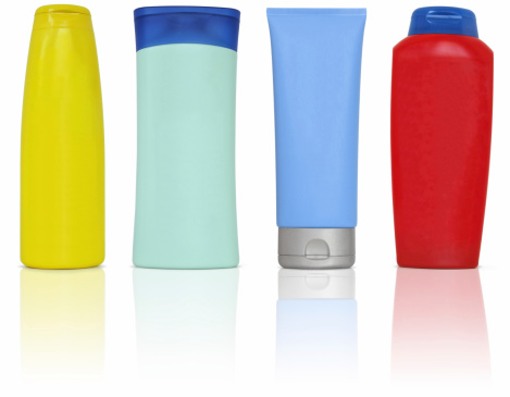 Colourful bottles of beauty products : conditioner, hand lotion, shampoo and shower gel. 