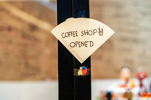 Open sign hanging on the door of a cafe