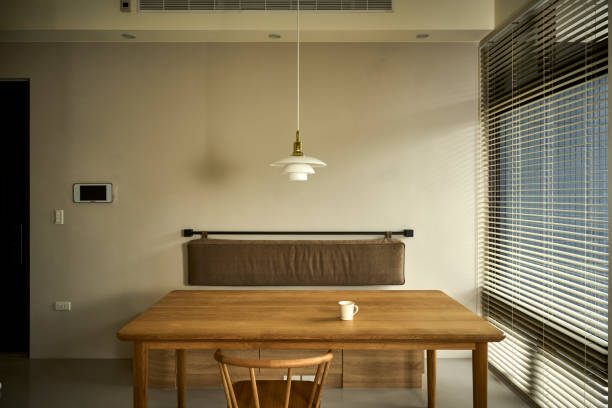 Home interior background with normcore design, table and decor in living room.Interior design of living room at nice apartment with simple and modern style. There is a wooden long table and a wooden chair.