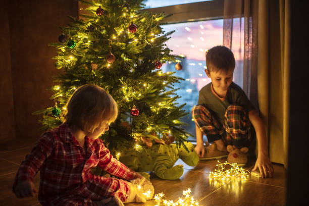 istock Children decorating Christmas tree at home in the evening 1722483567