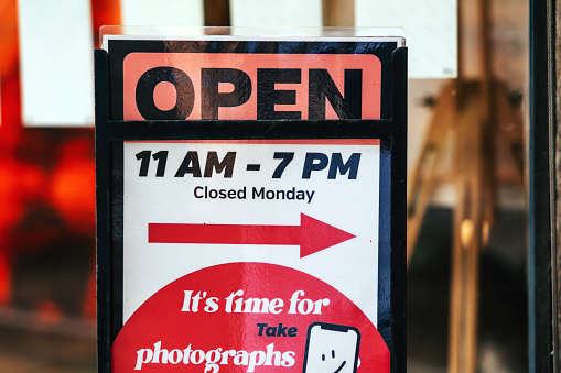 View through window of open sign in shop