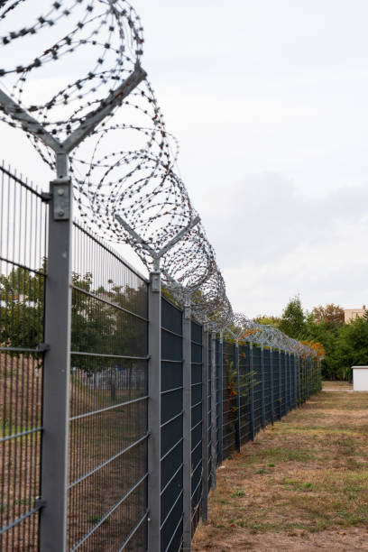 istock Barbed wire fence in urban environment. 1722484187