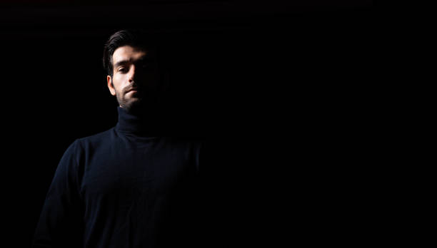 istock Confident thinking handsome young beared man portrait Attractive bearded confident guy planning something looking at blank space Smart man thinking in the dark room Confident Cool man looking at camera 1722490034