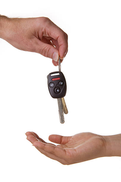 One hand dropping the car keys into another stock photo
