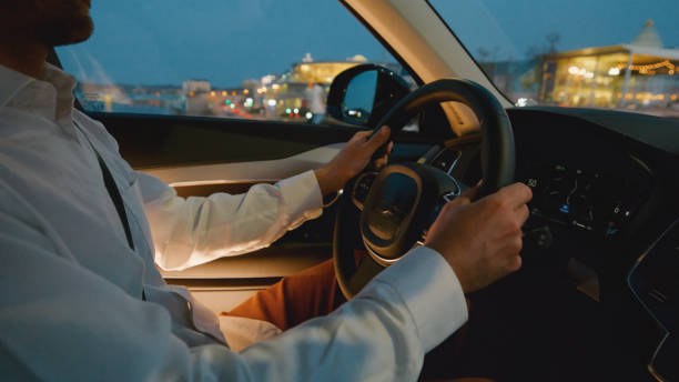 istock Young man driving car in illuminated city during blue hour 1722491766