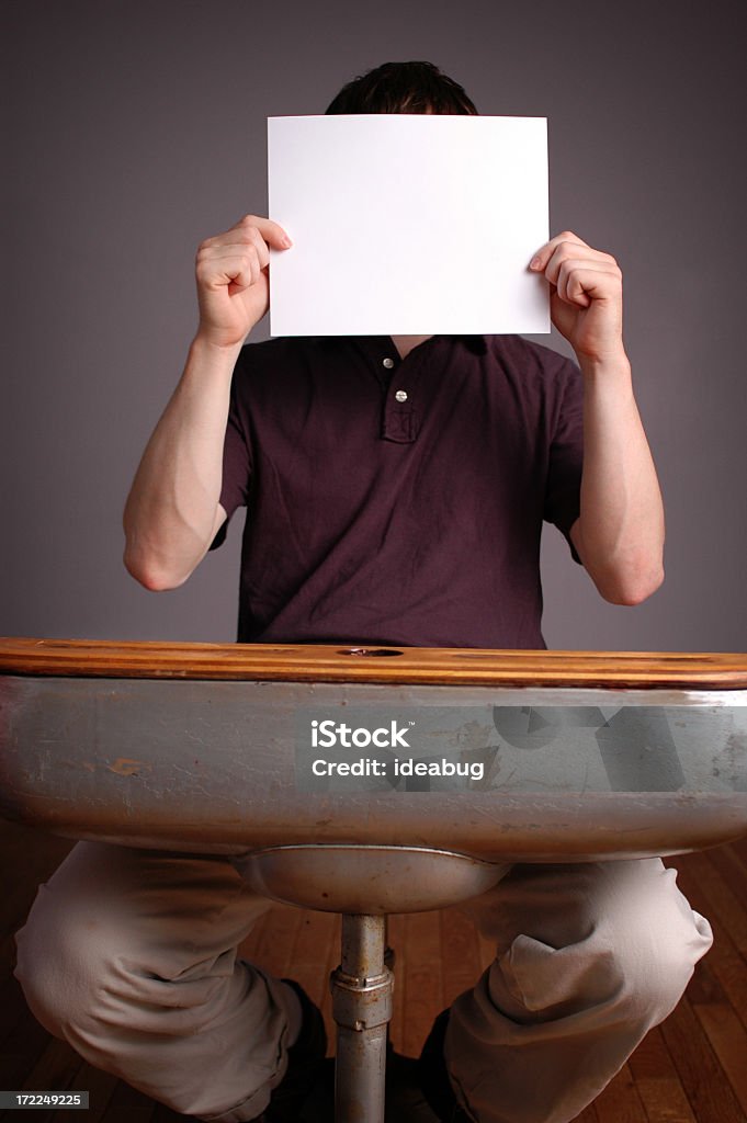Giovane uomo studente seduto alla scrivania con carta vuota - Foto stock royalty-free di Abbigliamento casual