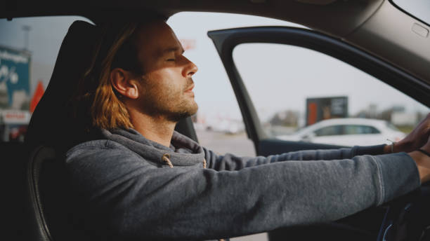 istock Relaxed young man inside new car with open door holding steering wheel 1722492404