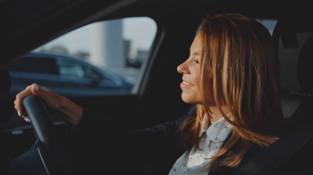 istock Smiling woman sitting inside car holding steering wheel ready for test drive 1722492998