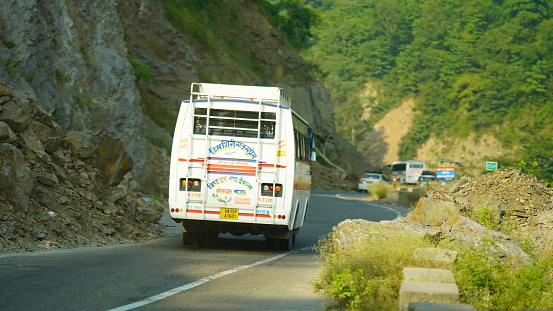 a white tourist bus is driving on mountain hills in kedarnath : 01 SEP. 2023 Shri Kedarnath Temple, dedicated to Lord Shiva, Rudraprayag district of Uttarakhand, India