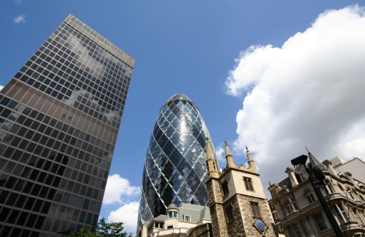 A couple of modern skyscrapers and older buildings in London city.